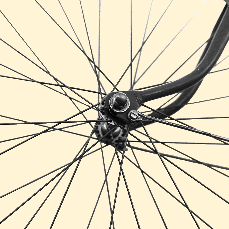 Photo en gros plan du centre d'une roue de vélo. Les rayons sont découper dans une forme carré qui donne un aspect très graphique à l'image.